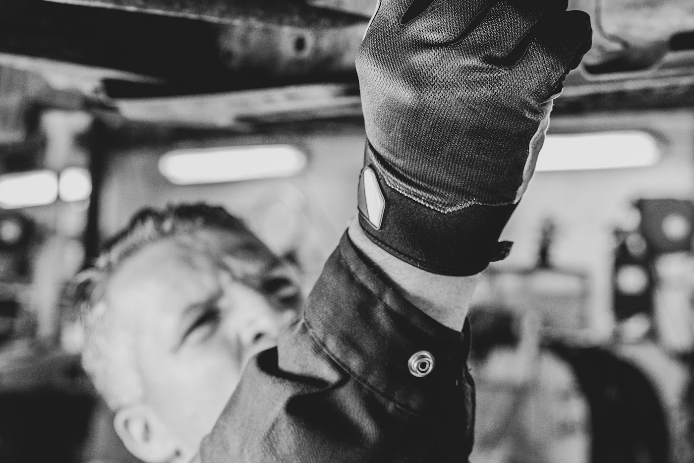 Mechanikas su pirštine tikrina automobilio dugną